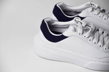 Temiz, izole edilmiş beyaz arka planda beyaz spor ayakkabıların yakın plan fotoğrafı, ayrıntılı dokular ve modern tasarım sergileniyor..