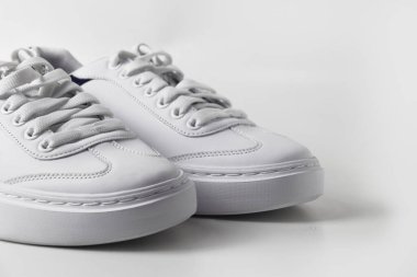 Beyaz arka planda izole edilmiş şık beyaz spor ayakkabıları..