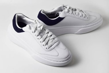 Beyaz arka planda izole edilmiş şık beyaz spor ayakkabıların üst görünümü.