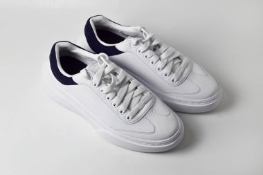 Beyaz arka planda izole edilmiş şık beyaz spor ayakkabıların üst görünümü.