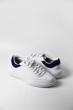 Beyaz arka planda izole edilmiş şık beyaz spor ayakkabıların üst görünümü.