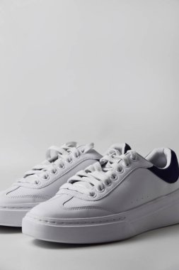 Sade beyaz arka planda bir çift parlak ve sade spor ayakkabısı modern ve temiz spor ya da günlük giysiler için..