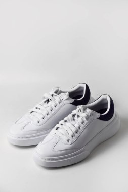 Sade beyaz arka planda bir çift parlak ve sade spor ayakkabısı modern ve temiz spor ya da günlük giysiler için..