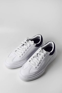 Sade beyaz arka planda bir çift parlak ve sade spor ayakkabısı modern ve temiz spor ya da günlük giysiler için..