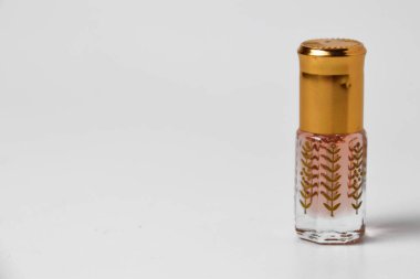 Küçük ve eşsiz plastik bir kapta, beyaz izole edilmiş bir arka planda parfümün yakın plan fotoğrafı..