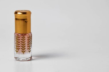 Küçük ve eşsiz plastik bir kapta, beyaz izole edilmiş bir arka planda parfümün yakın plan fotoğrafı..