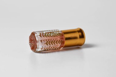 Küçük ve eşsiz bir plastik tutacağı olan, beyaz, izole bir arka planda duran hoş kokulu bir parfüm..