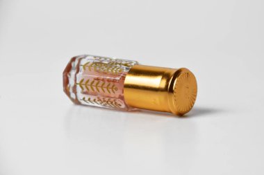 Küçük ve eşsiz bir plastik tutacağı olan, beyaz, izole bir arka planda duran hoş kokulu bir parfüm..