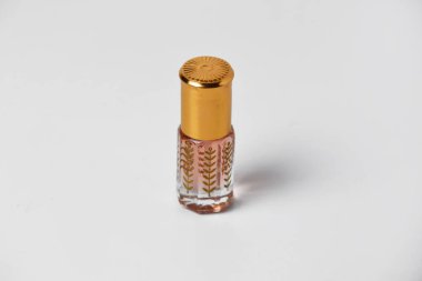 Küçük ve eşsiz bir plastik tutacağı olan, beyaz, izole bir arka planı olan hoş bir parfüm..