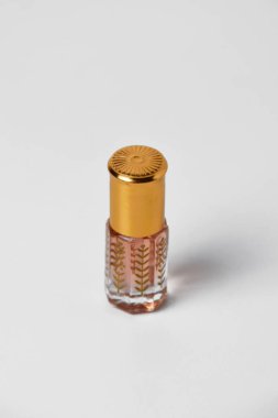 Küçük ve eşsiz bir plastik tutacağı olan, beyaz, izole bir arka planı olan hoş bir parfüm..