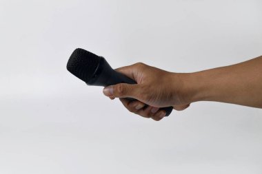 İzole edilmiş beyaz arka planı olan bir mikrofonu tutan bir erkek. Ses, şarkı, özgürlük, direniş veya demokrasi temaları için mükemmel.