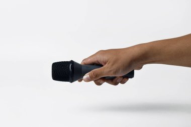 İzole edilmiş beyaz arka planı olan bir mikrofonu tutan bir erkek. Ses, şarkı, özgürlük, direniş veya demokrasi temaları için mükemmel.