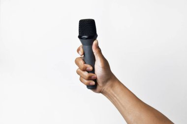 İzole edilmiş beyaz arka planı olan mikrofonu tutan bir adamın tek eli. Şarkı söylemek, konuşmak, ilahi söylemek, direniş ve demokrasi için uygun bir tema.