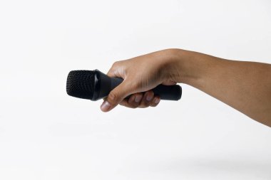 İzole edilmiş beyaz arka planı olan bir mikrofonu tutan bir erkek. Ses, şarkı, özgürlük, direniş veya demokrasi temaları için mükemmel.