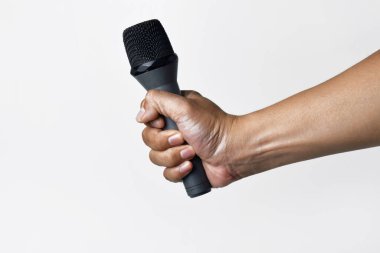 Asyalı bir adamın el ele tutuşması ve beyaz arka planda izole edilmiş bir mikrofon kullanması. Şarkı söyleme, konuşma, direniş, ifade ve demokrasi kavramı.