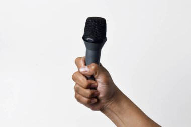 Aşağıdan beyaz izole edilmiş bir arka planı olan bir mikrofon tutan kişi. Konuşmanın, şarkı söylemenin, direnişin ve demokrasinin sembolü.