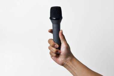 Aşağıdan beyaz izole edilmiş bir arka planı olan bir mikrofon tutan kişi. Konuşmanın, şarkı söylemenin, direnişin ve demokrasinin sembolü.