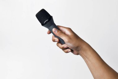 Aşağıdan beyaz izole edilmiş bir arka planı olan bir mikrofon tutan kişi. Konuşmanın, şarkı söylemenin, direnişin ve demokrasinin sembolü.