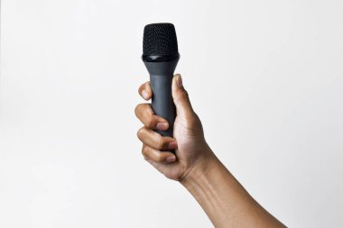 Aşağıdan beyaz izole edilmiş bir arka planı olan bir mikrofon tutan kişi. Konuşmanın, şarkı söylemenin, direnişin ve demokrasinin sembolü.