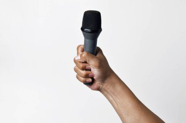 Aşağıdan beyaz izole edilmiş bir arka planı olan bir mikrofon tutan kişi. Konuşmanın, şarkı söylemenin, direnişin ve demokrasinin sembolü.