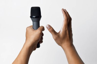 Bir kişi aşağıdan bir mikrofon tutar ve diğer el yukarı doğru sarılır ve beyaz izole bir arka plan oluşturur. Konuşma, şarkı söyleme, direniş ve demokrasinin sembolü.