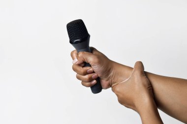 Asyalı bir adamın el ele tutuşması ve beyaz arka planda izole edilmiş bir mikrofon kullanması. Şarkı söyleme, konuşma, direniş, ifade ve demokrasi kavramı.