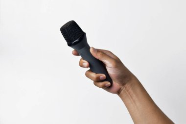 Aşağıdan beyaz izole edilmiş bir arka planı olan bir mikrofon tutan kişi. Konuşmanın, şarkı söylemenin, direnişin ve demokrasinin sembolü.