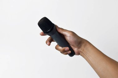 Asyalı bir adamın el ele tutuşması ve beyaz arka planda izole edilmiş bir mikrofon kullanması. Şarkı söyleme, konuşma, direniş, ifade ve demokrasi kavramı.