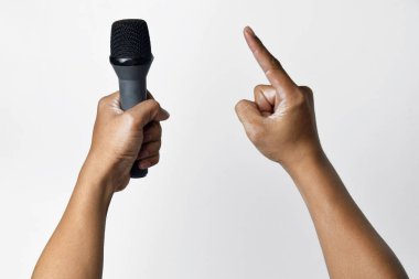 Bir elinde mikrofon tutan Asyalı bir adamın diğer elinde ise beyaz bir arka plan. Şarkı söylemenin, konuşmanın, direnişin ve demokrasinin sembolü.