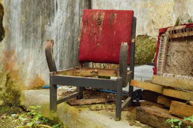 Geleneksel ahşaptan yapılmış eski ve hasarlı bir kırmızı sandalye Tasikmalaya, Batı Java, Endonezya 'da bir kırsal evde oturuyor..