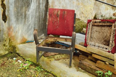 Geleneksel ahşaptan yapılmış eski ve hasarlı bir kırmızı sandalye Tasikmalaya, Batı Java, Endonezya 'da bir kırsal evde oturuyor..