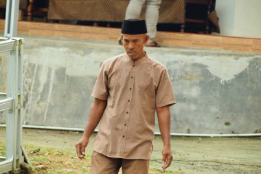 Tasik, Endonezya - 2 Nisan 2025: Tasikmalaya, Batı Java, Endonezya 'da geleneksel bir etkinliğe katılmak için Batik ve geleneksel Endonezya şapkaları giyen orta yaşlı erkekler.