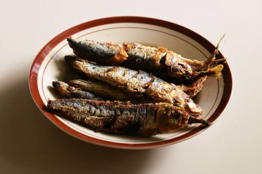 Bazı geleneksel Endonezya kızarmış balıkları izole edilmiş krema arka planlı bir tabakta servis edilir..