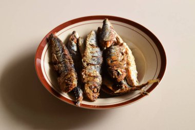 Bazı geleneksel Endonezya kızarmış balıkları izole edilmiş krema arka planlı bir tabakta servis edilir..