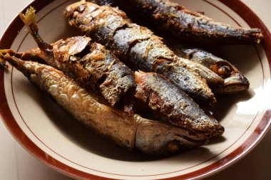 Geleneksel Endonezya kızarmış balığının yakın plan fotoğrafı izole edilmiş bir tabakta servis ediliyor..