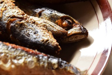 Birkaç geleneksel Endonezya kızarmış balığının balık kafaları izole edilmiş krema arkaplanlı bir tabakta servis ediliyor..