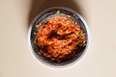 Kırmızı biberli, domates soslu ve çok lezzetli bir Endonezya sambali olan karides ezmesi tabakta ve izole edilmiş krema arkaplanda..