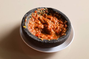 Kırmızı biber ve domates sosu ve biraz da karides ezmesi. Tipik bir Endonezya sosu. Tabakta çok lezzetli ve izole edilmiş krema arkaplanı..