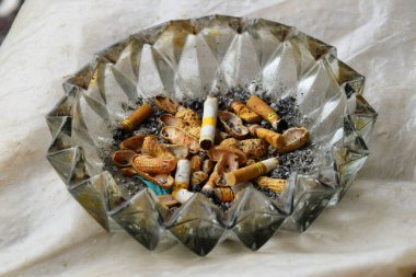 Sigara ve kirli küller cam kül tablasında..