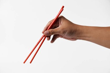 Bir adamın eli kırmızı yemek çubuğunu sanki beyaz izole edilmiş bir arka planı varmış gibi tutar..