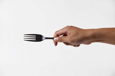 Asyalı bir adamın eli çelik bir çatal tutuyor. Yüzünde yalıtılmış beyaz bir arka planı varmış gibi bir ifade var..