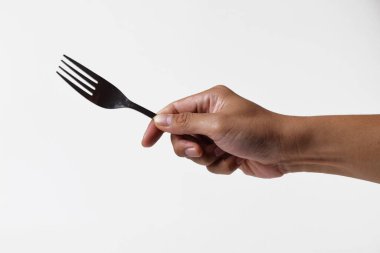 Asyalı bir adamın eli çelik bir çatal tutuyor. Yüzünde yalıtılmış beyaz bir arka planı varmış gibi bir ifade var..