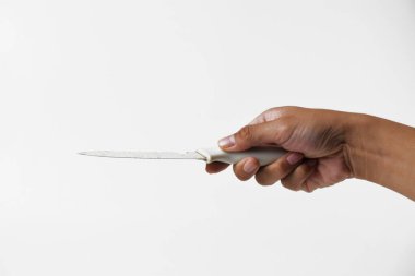 Asyalı bir adamın eli beyaz bir bıçağı bir şeyi bıçaklama ifadesi ile tutuyor. Arkaplan izole edilmiş beyaz.