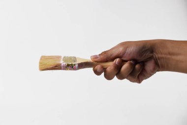 İzole edilmiş beyaz bir arka planda resim yapmak için fırça tutan bir adam..