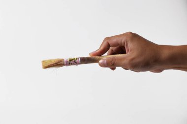 İzole edilmiş beyaz bir arka planda resim yapmak için fırça tutan bir adam..