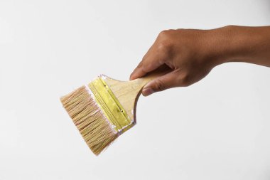 İzole edilmiş beyaz bir arka planda resim yapmak için fırça tutan bir adam..