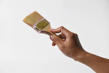 İzole edilmiş beyaz bir arka planda resim yapmak için fırça tutan bir adam..