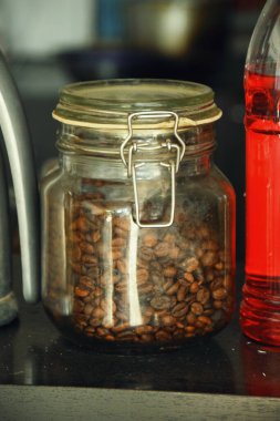 Endonezya 'da geleneksel bir kafede bir kavanoz kahve çekirdeği bir masada duruyor..