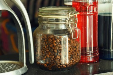 Endonezya 'da geleneksel bir kafede bir kavanoz kahve çekirdeği bir masada duruyor..