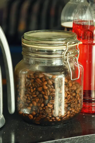 Endonezya 'da geleneksel bir kafede bir kavanoz kahve çekirdeği bir masada duruyor..